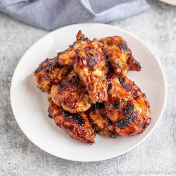 A plate filled with BBQ wings.