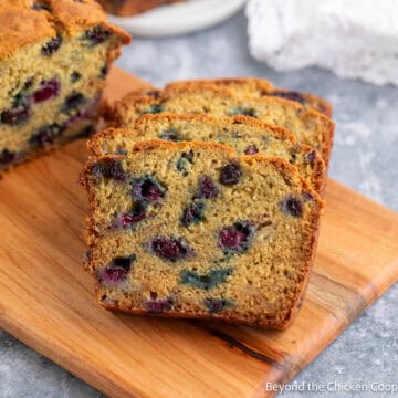 Sliced Blueberry Banana Bread on a wooden cutting board.